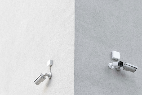 Two security cameras mounted on a concrete wall