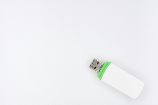 A USB flash drive on a white surface - the simplest form of backup