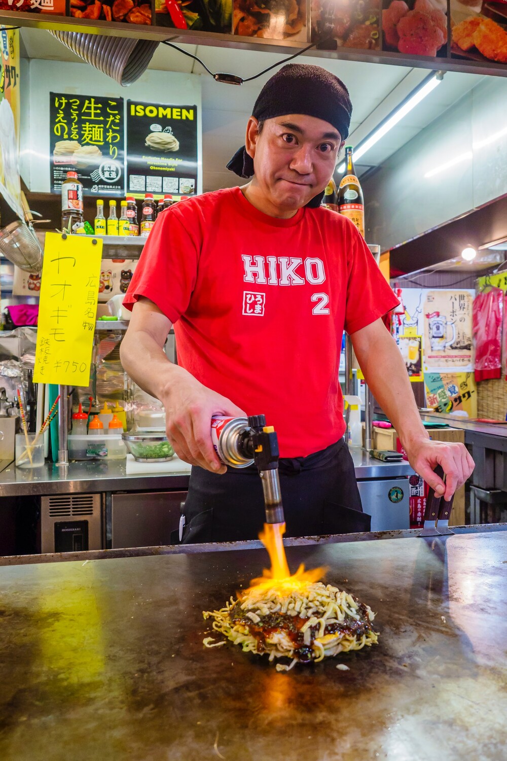 Japanese chef using a blowtorch to finish a dish at a food stall - the right tool for the job